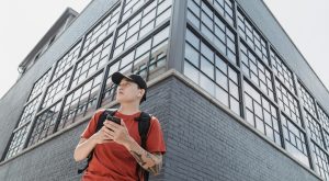 man standing on a street corner holding a cell phone