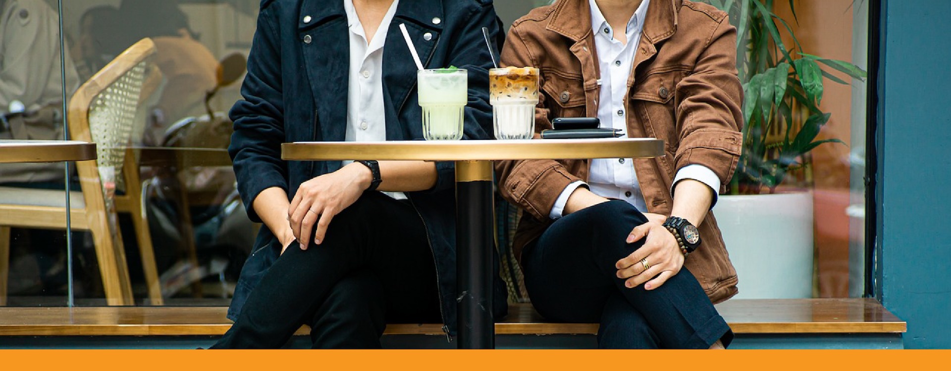 2 people sit at table with iced coffees